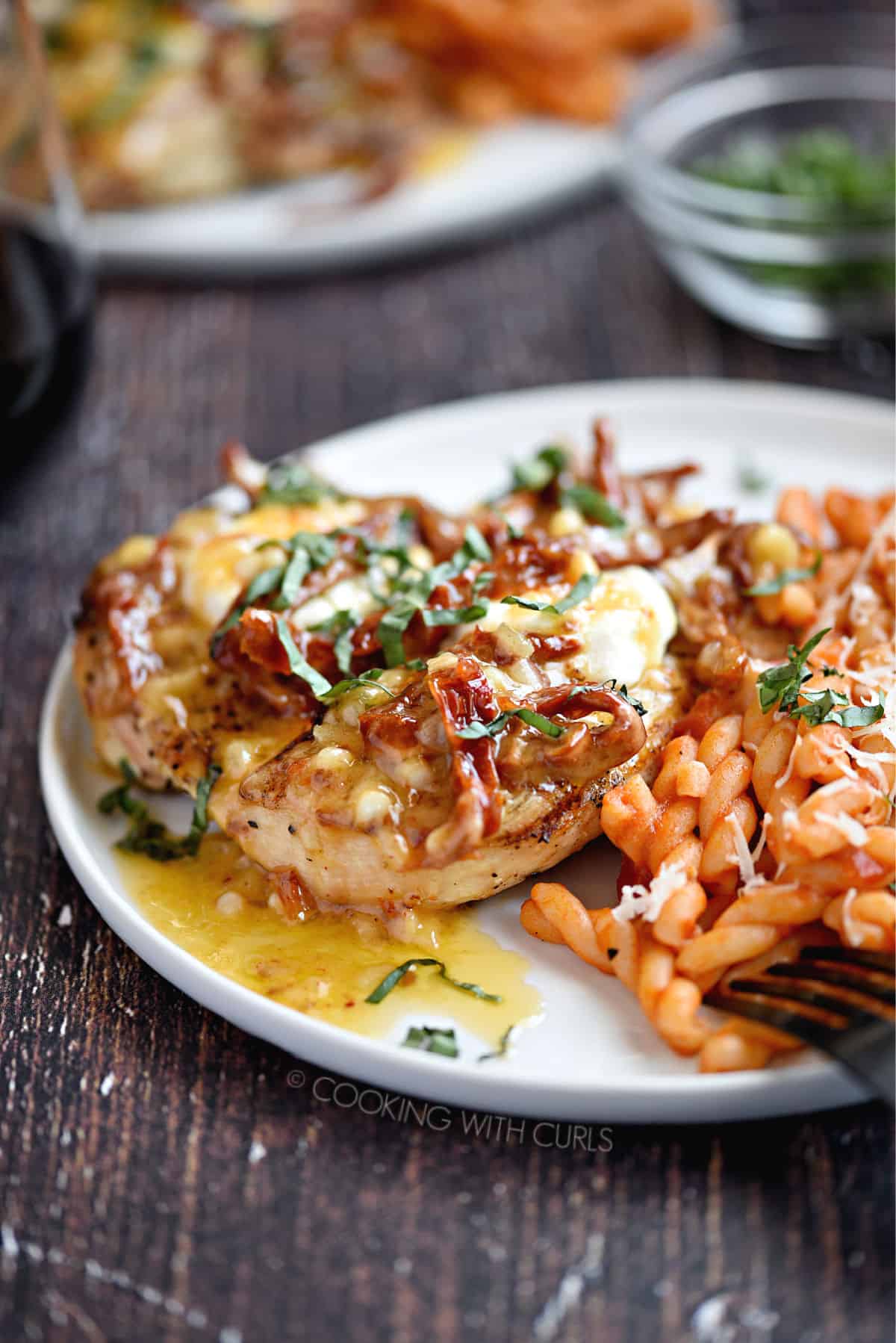 Butterflied chicken breast, goat cheese, lemon-butter sauce, sun-dried tomatoes and fresh basil served with a side of curly pasta mixed with red sauce.