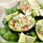 Three Healthy Tuna Stuffed Avocado on a bed of cilantro leaves
