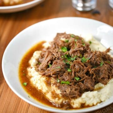 Two bowls of Instant Pot Cafe Mocha Pot Roast served over mashed cauliflower