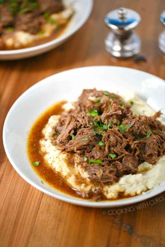 Two bowls of Instant Pot Cafe Mocha Pot Roast served over mashed cauliflower