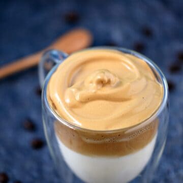 Looking down on a clear glass mug filled with Whipped Dalgona Coffee.