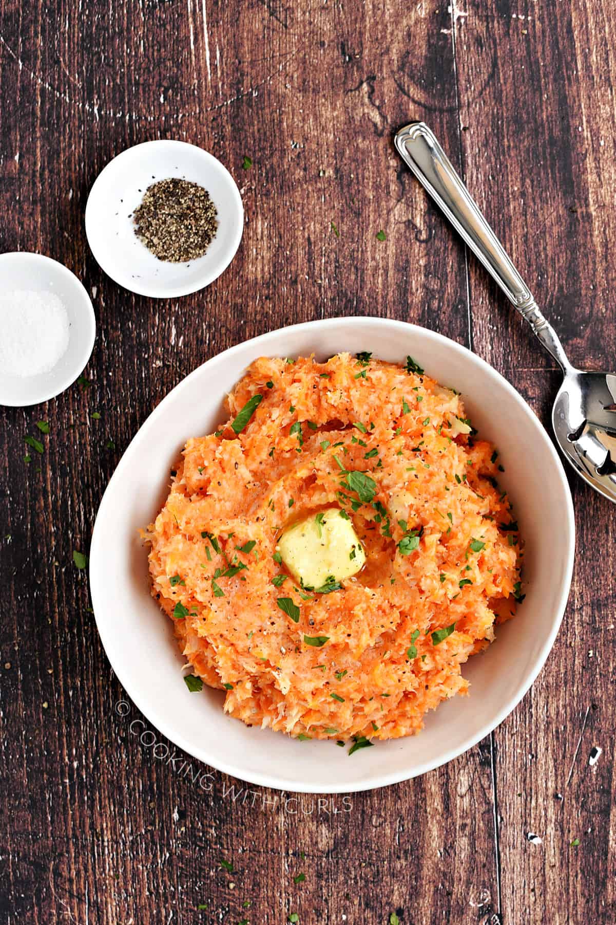 A big white bowl filled with mashed carrots and parsnips. 