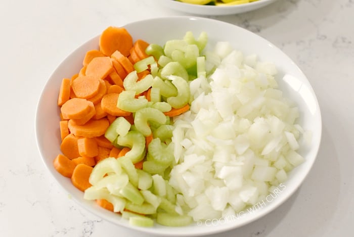 A bowl of sliced carrots, celery, and diced onions cookingwithcurls.com