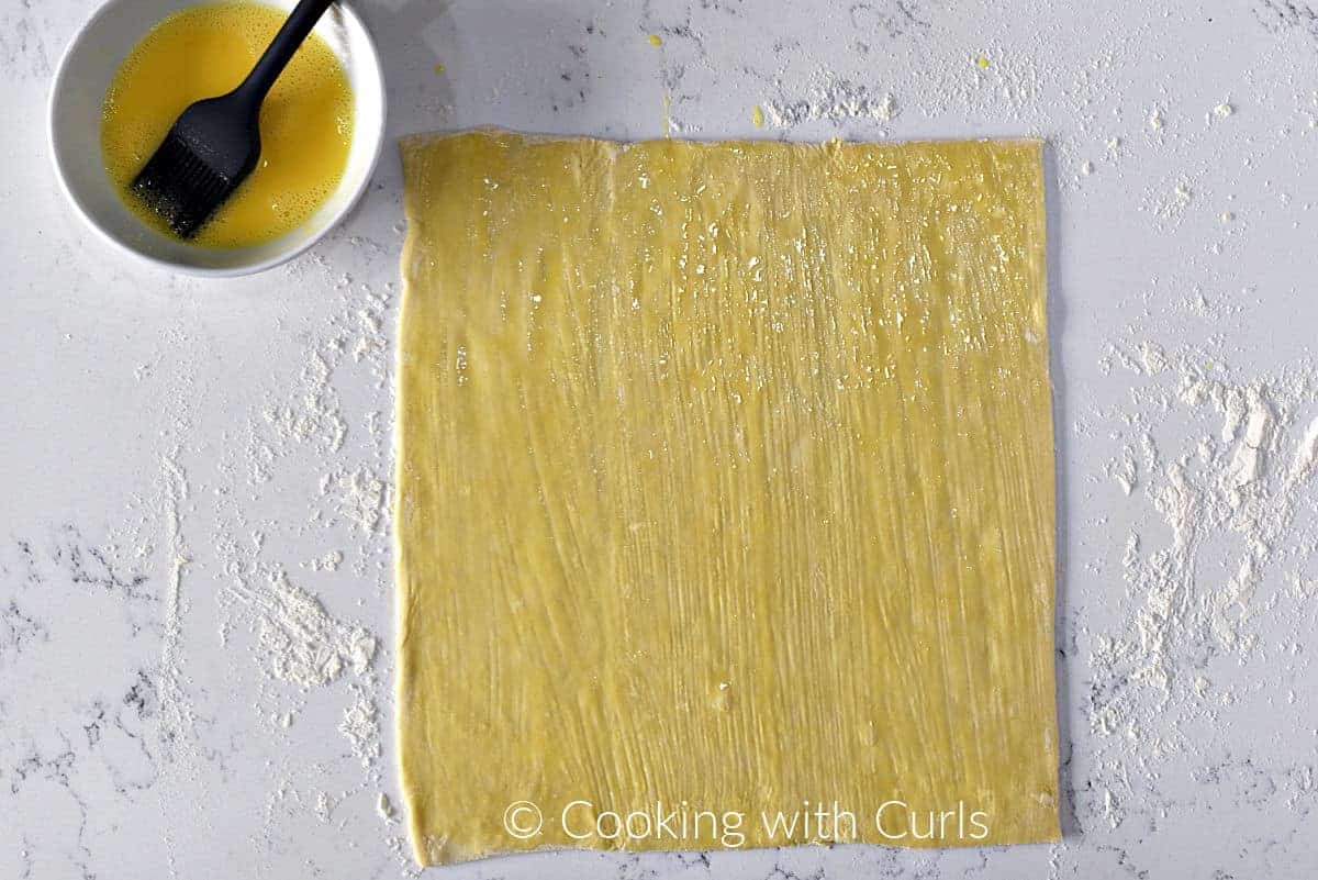 A sheet of puff pastry brushed with egg wash. 