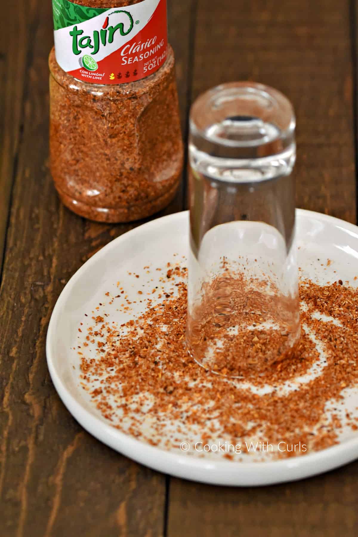 A small plate with chili spice mixture and rim-side down shot glass. 