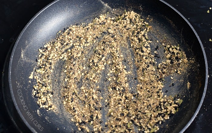 A small skillet with spices and sesame seeds 