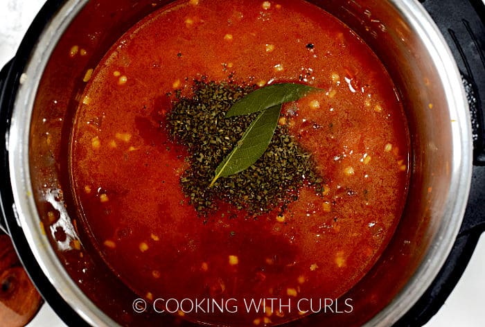 A split bay leaf and dried basil added to the soup mixture. 