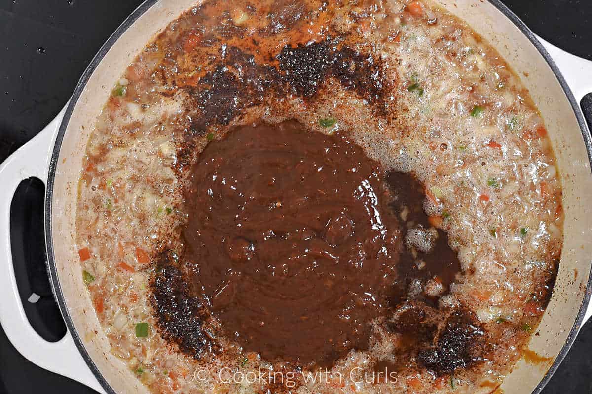 Barbecue sauce, beer, and spices simmering in a skillet.