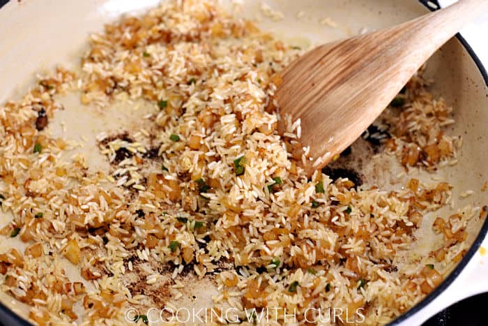 Browning rice with the sautéed onions in a skillet. 