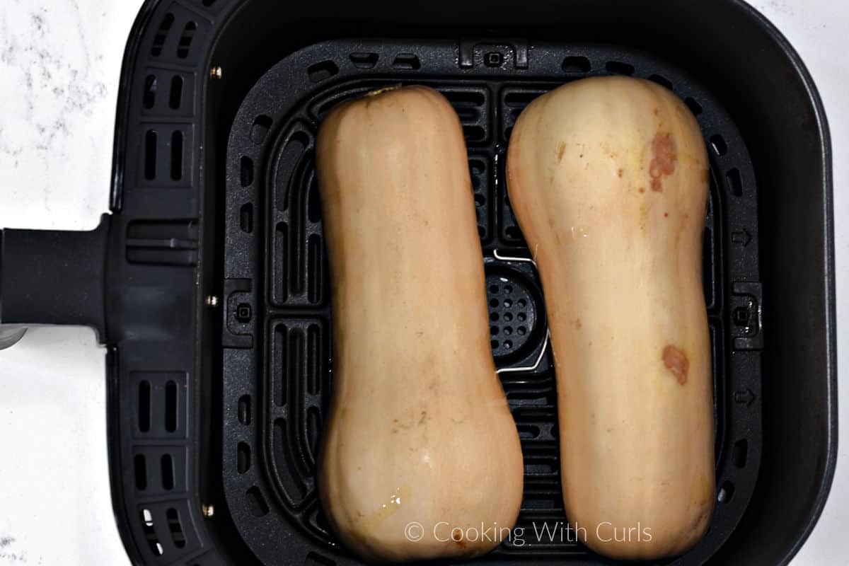 Butternut Squash halves flesh side down in an air fryer. 