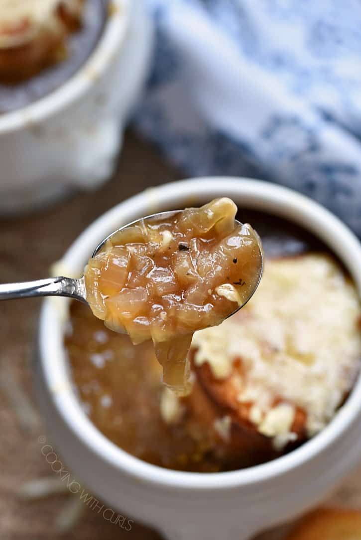 Caramelized onion soup on a spoon.