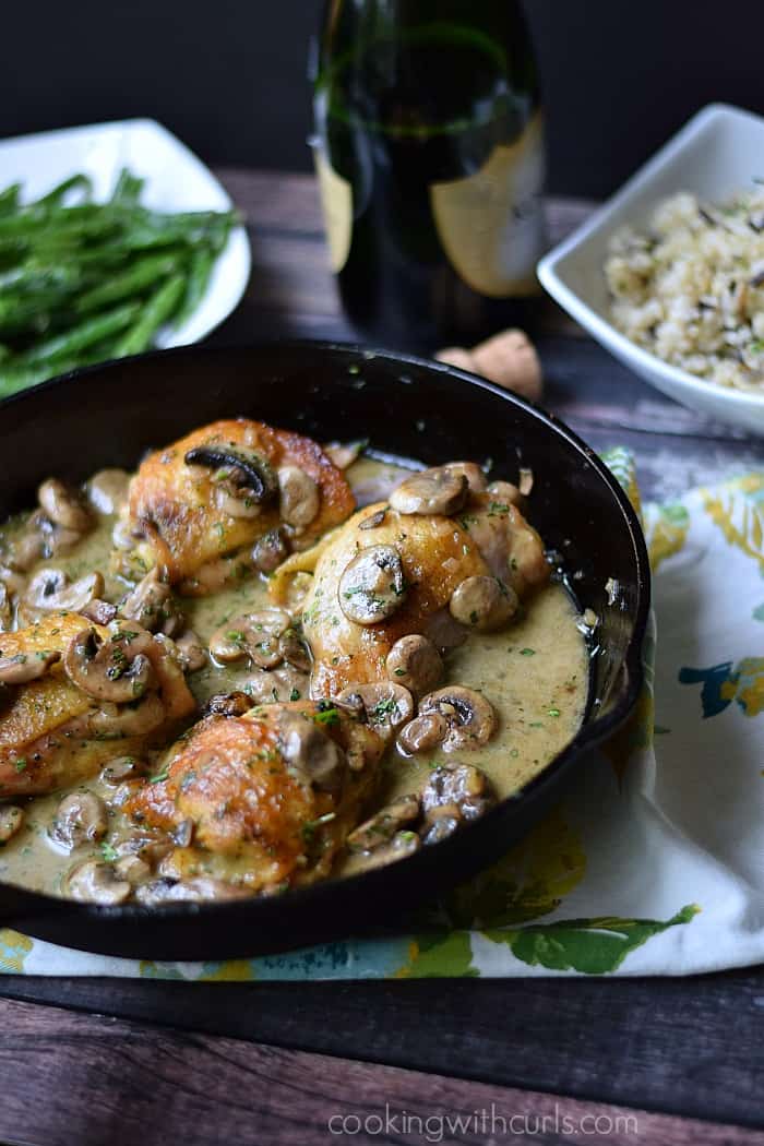 Chicken thighs cooked in a cast iron skillet with a creamy mushroom sauce.