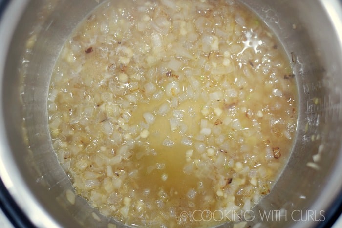 Chicken stock added to the onions and garlic.