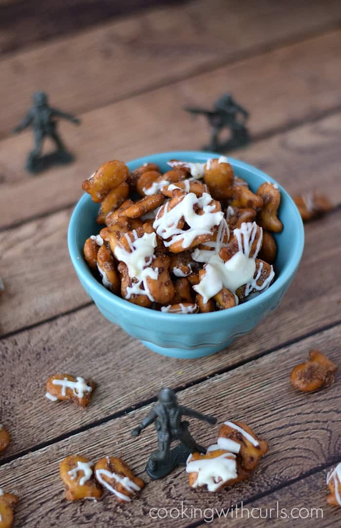 Cinnamon Sugar Goldfish Pretzel Mix in a small bowl surrounded by plastic army men and scattered pretzel mix.