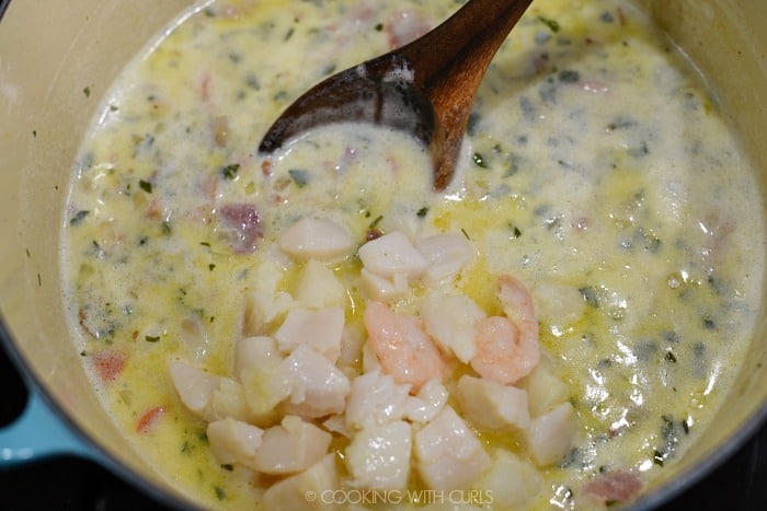 Cooked seafood added back into the large pan. 