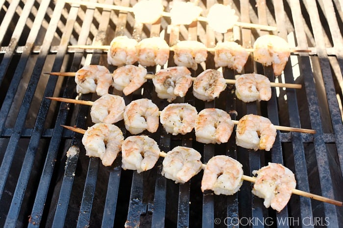 Cooked, skewered shrimp on the grill. 