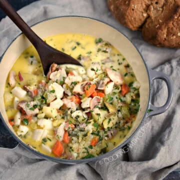 Looking down on Creamy Seafood Chowder with a loaf of Irish Brown Soda Bread in the background.