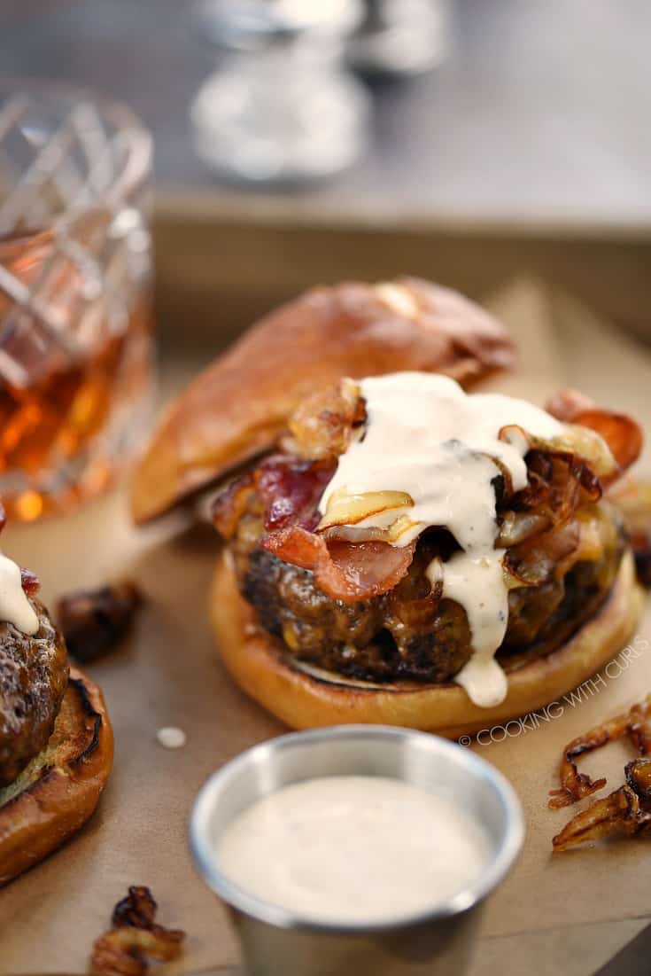 Crispy bacon, cheddar cheese, grilled onions and whiskey aioli top these half pound beef patties on pretzel buns.