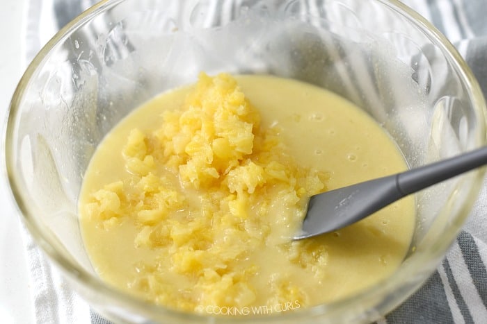 Crushed pineapple stirred into the filling mixtures with a gray rubber spatula. 