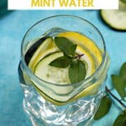 A glass of cucumber lemon mint water with slices of cucumber and lemon in the background.