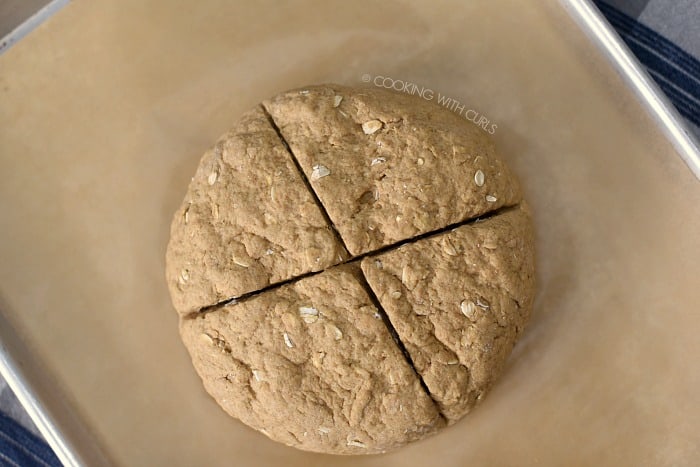 Cut a deep cross into the top of the bread dough circle. 