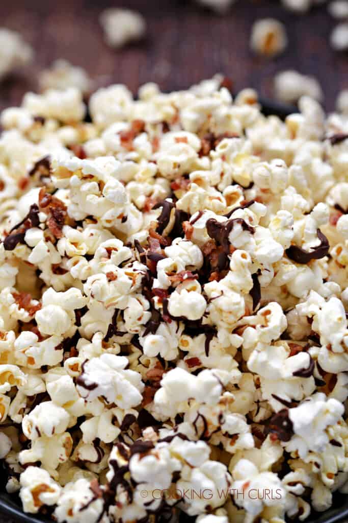 A close-up image of Instant Pot Chocolate Bacon Popcorn in a dark blue bowl. 
