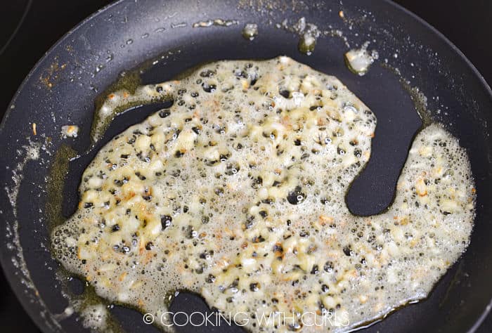 Diced onion and garlic simmering in melted butter in a small skillet. 