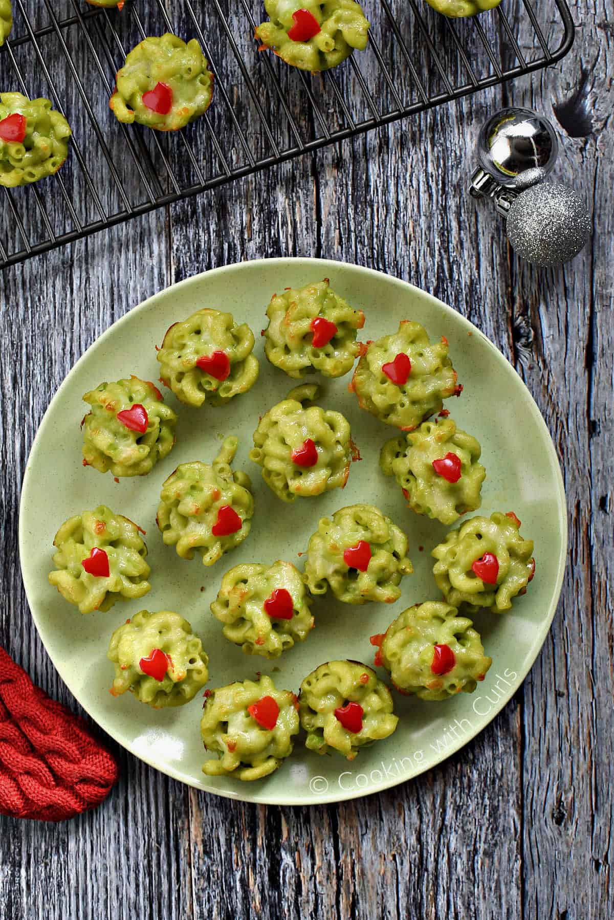 Looking down on a plate full of Grinch Mac and Cheese mini Bites.