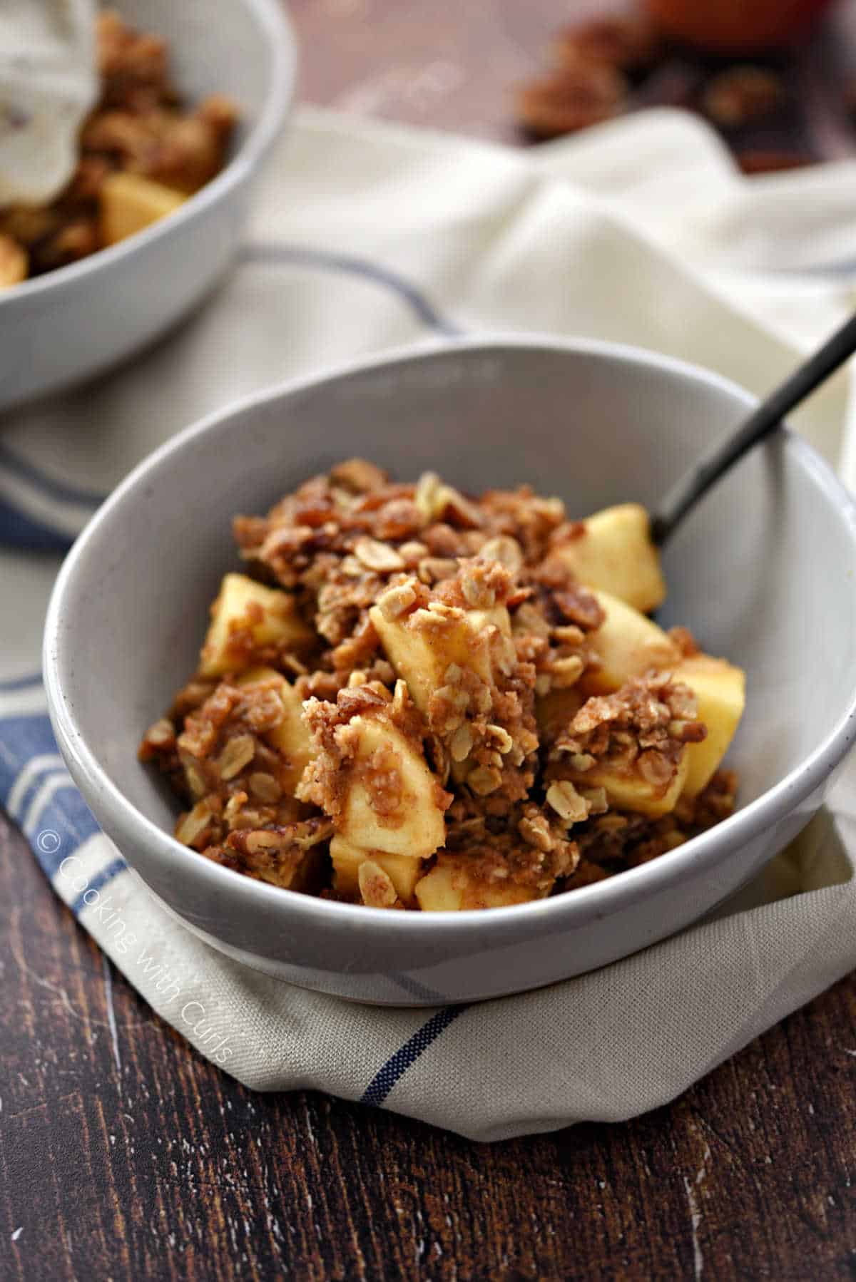 Apple chunks topped with oatmeal crumble in a serving bowl.