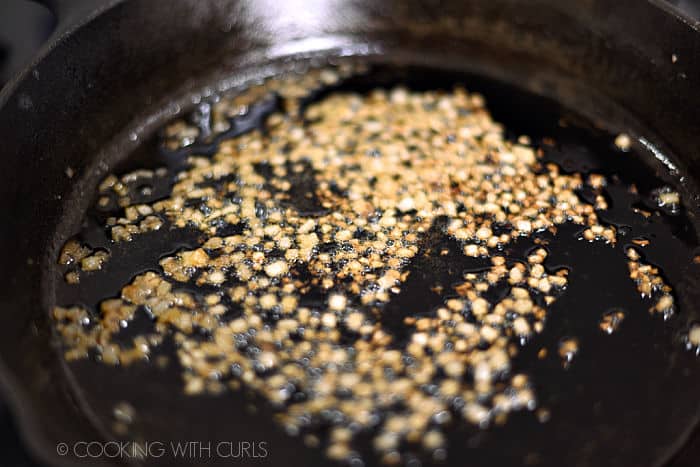 finely diced onion cooking in a cast iron skillet. 