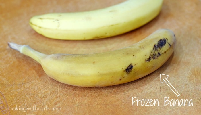 2 frozen bananas on a cutting board.