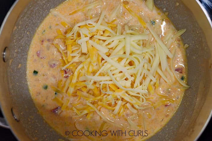 Grated cheese added to the saucepan. 