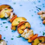 grilled shrimp and peach kabobs on metal skewers, drizzled with glaze laying on a blue background.