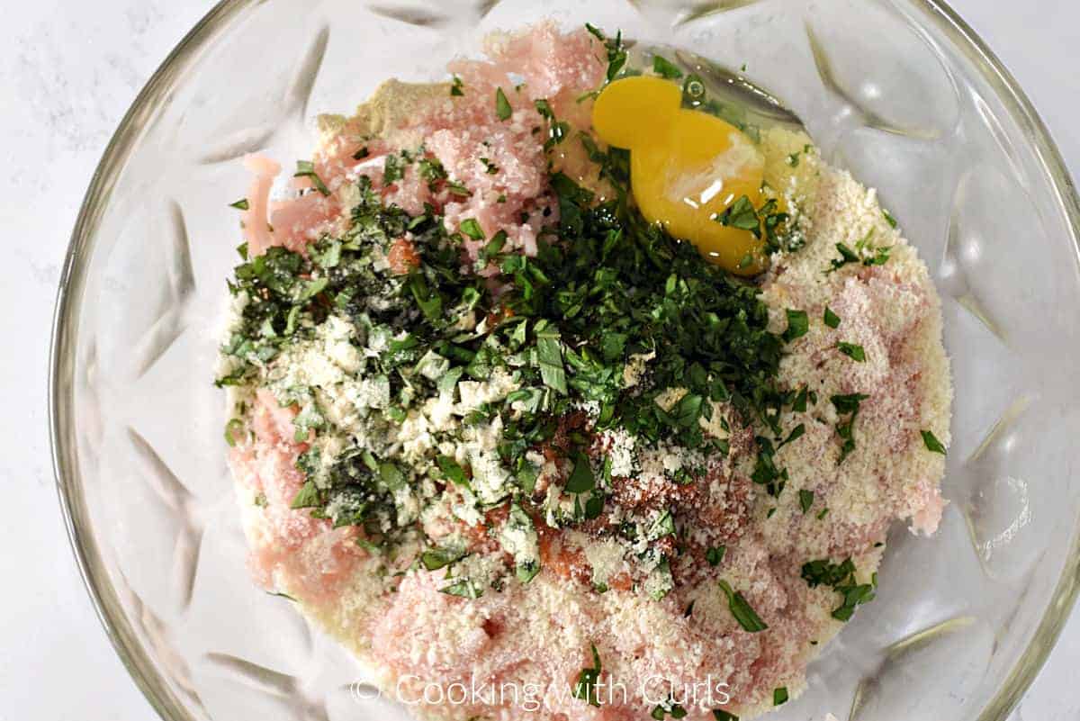 Ground chicken, egg, breadcrumbs, parsley, and tomato bruschetta in a large mixing bowl. 