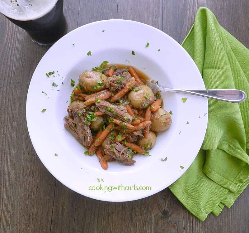 Looking down on Guinness Pot Roast with potatoes and carrots in a bowl.