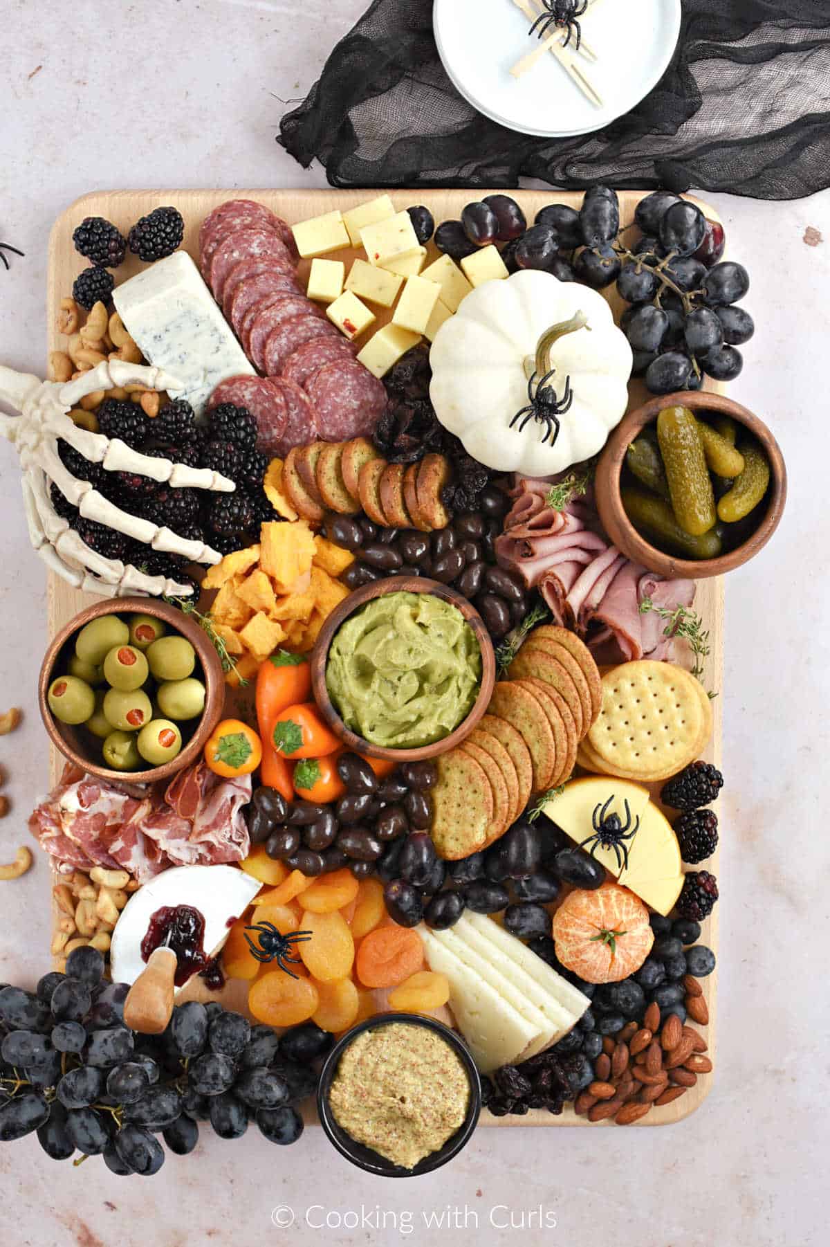 Halloween themed charcuterie board with meats, cheeses, crackers, and fruits.