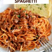 Spaghetti with meat sauce on a white plate with garlic bread on the side and title graphic across the top.