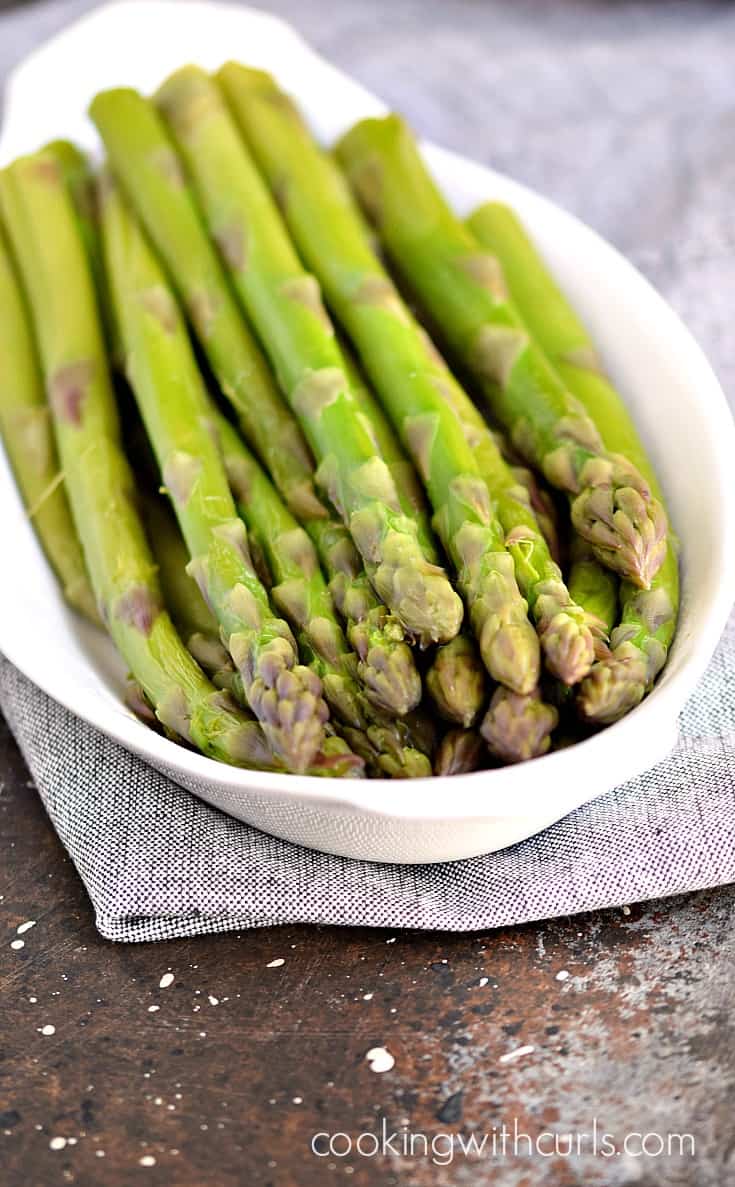 A small serving platter filled with steamed asparagus spears.