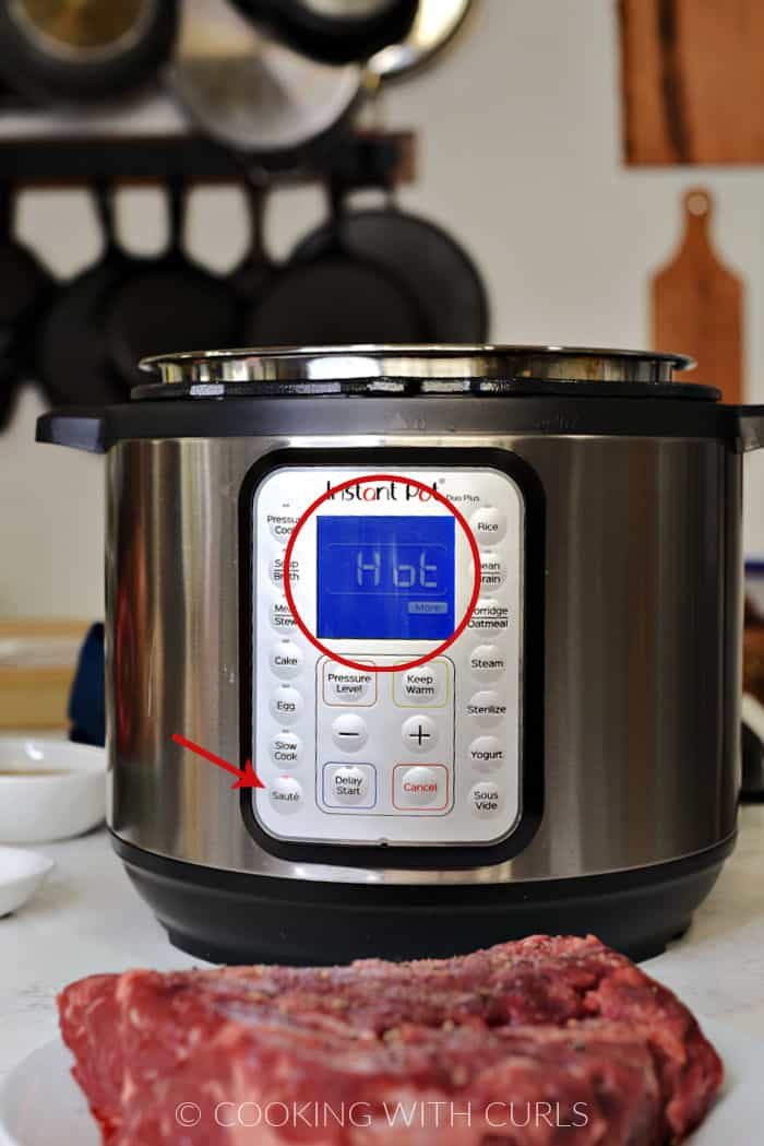 Instant Pot with red arrow to the Sauté button and red circle around HOT on the display. 