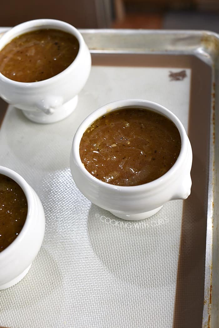 Soup in oven safe bowls on a baking sheet.