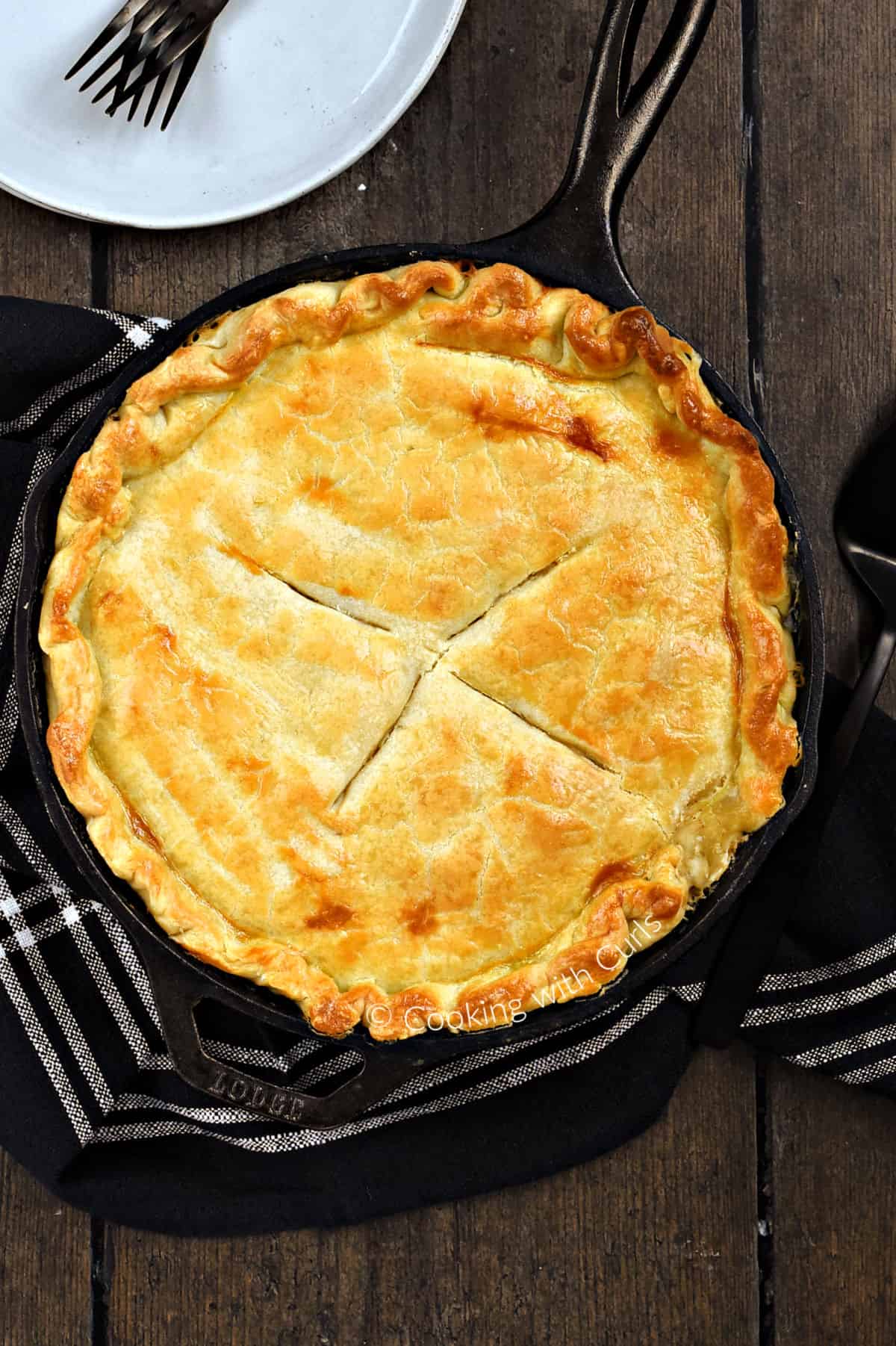 Looking down on a Skillet Chicken Pot Pie with plates and forks in the background. 