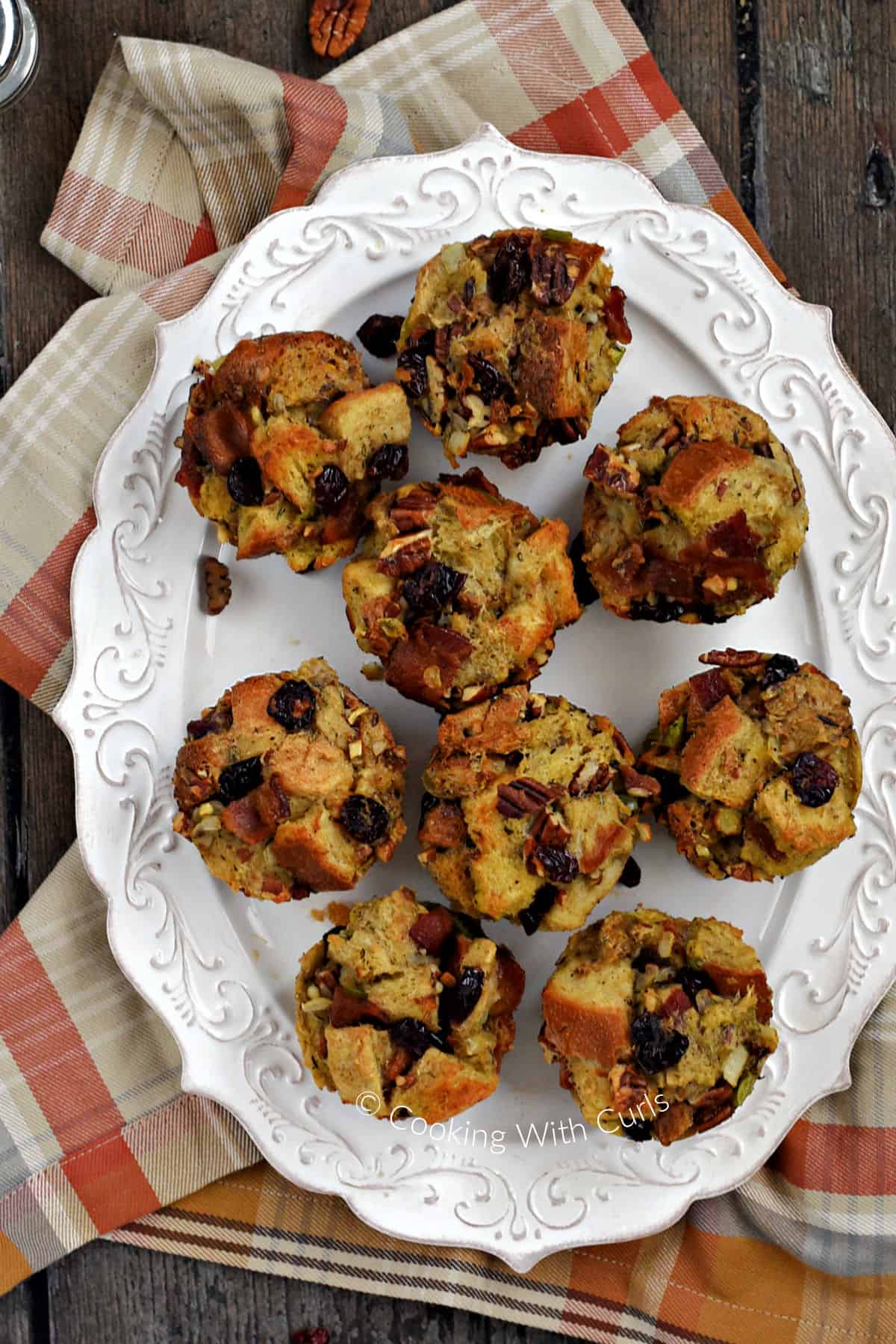 Looking down on nine stuffing muffins on an oval serving platter. 