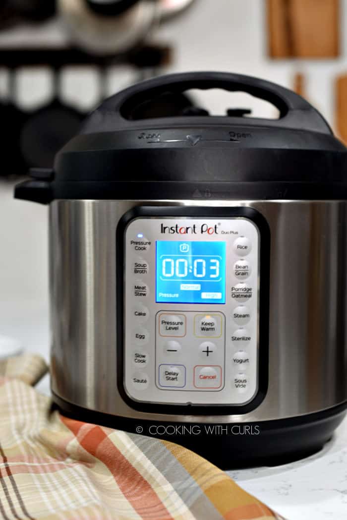 Looking straight at an Instant Pot pressure cooker with the display reading three minutes. 