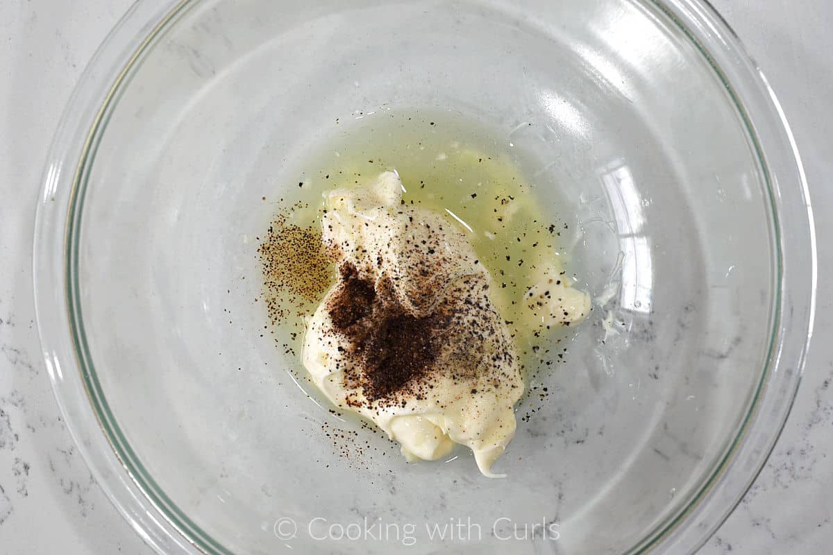 Mayonnaise, garlic, lime juice, and chili powder in a mixing bowl.