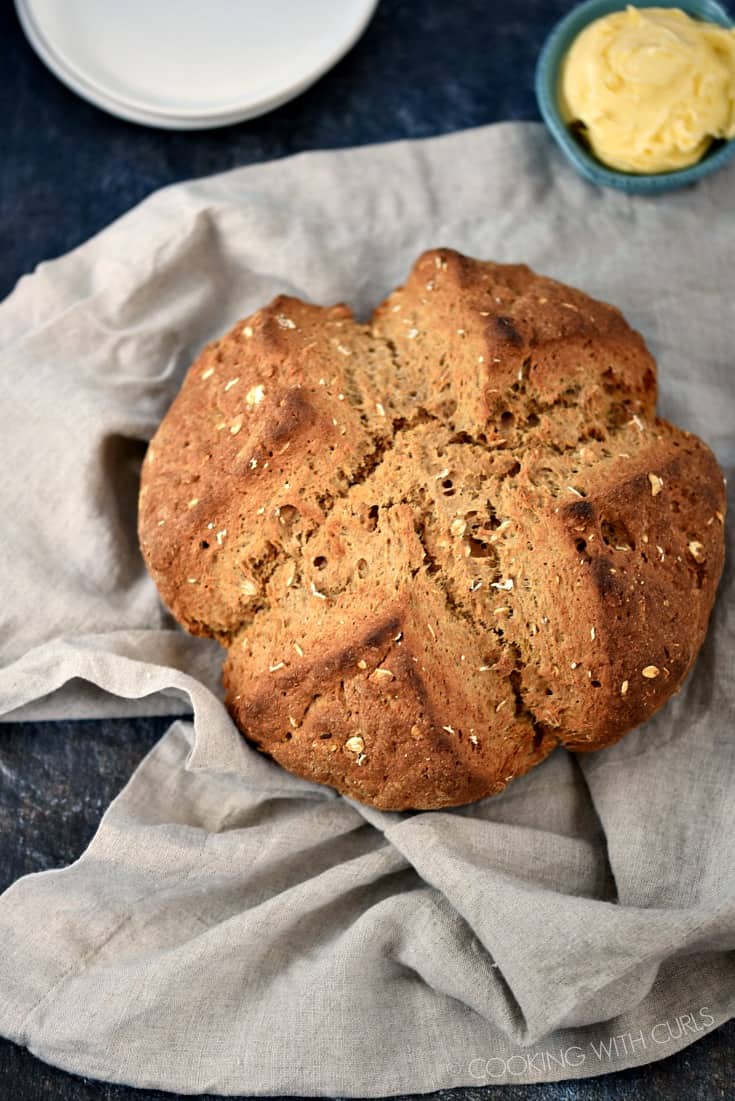 Looking down on a loaf of Irish Brown Soda Bread cooling on a beige napkin.