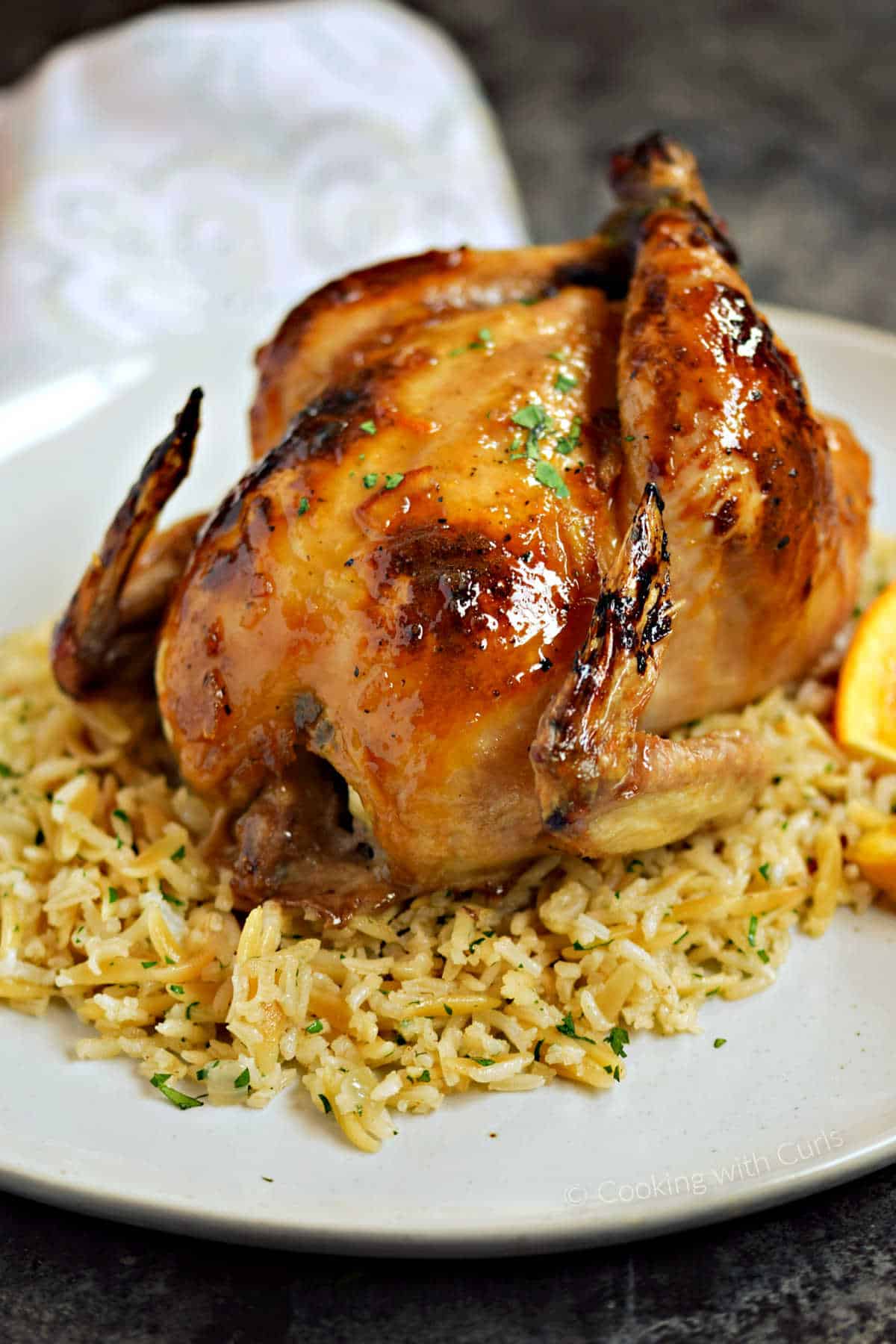 Orange glazed Cornish game hen on a bed of rice pilaf.