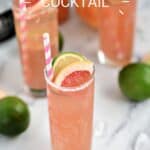 A bubbly, pink cocktail in a tall glass garnished with a slice of lime and grapefruit with a pink and white striped straw and title graphic across the top.