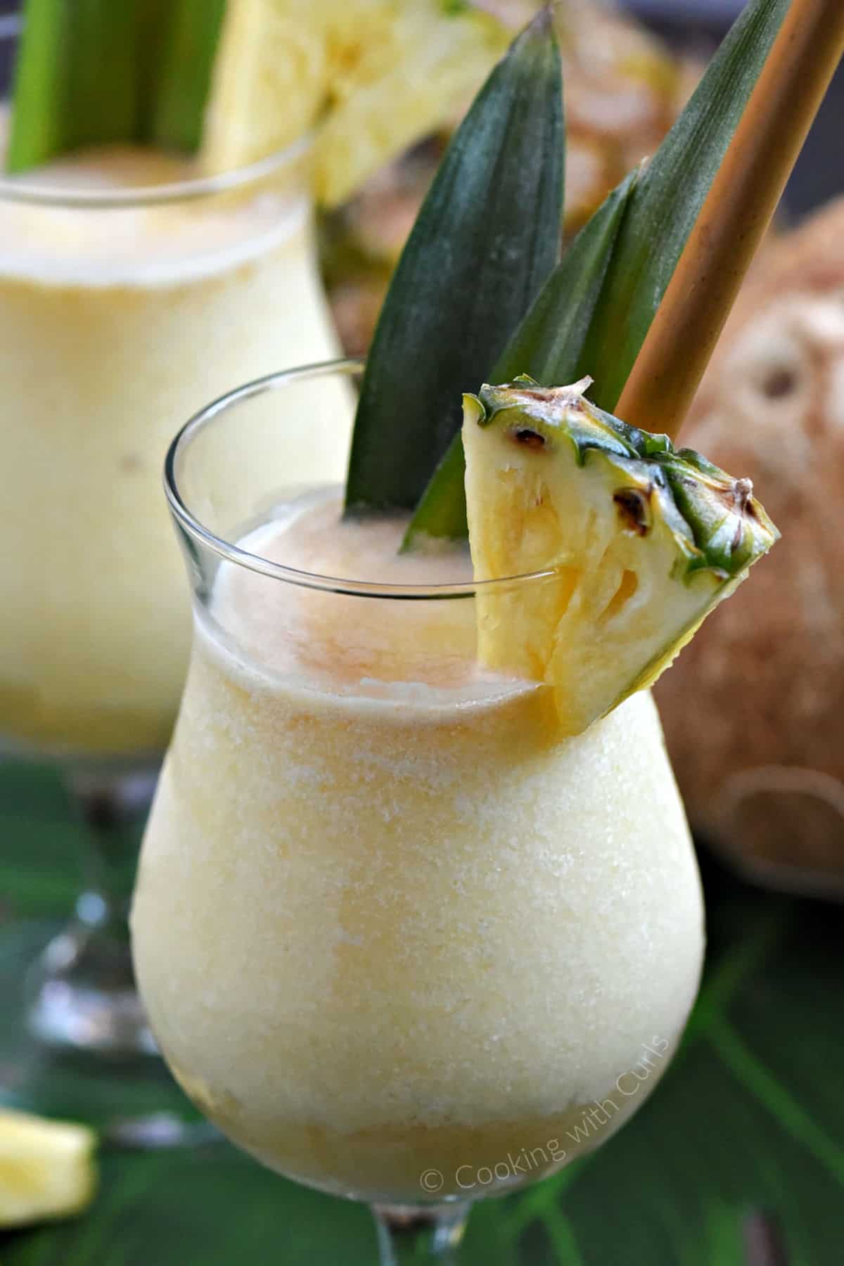 Pina Colada topped with dark rum and garnished with pineapple leaves and wedge. 