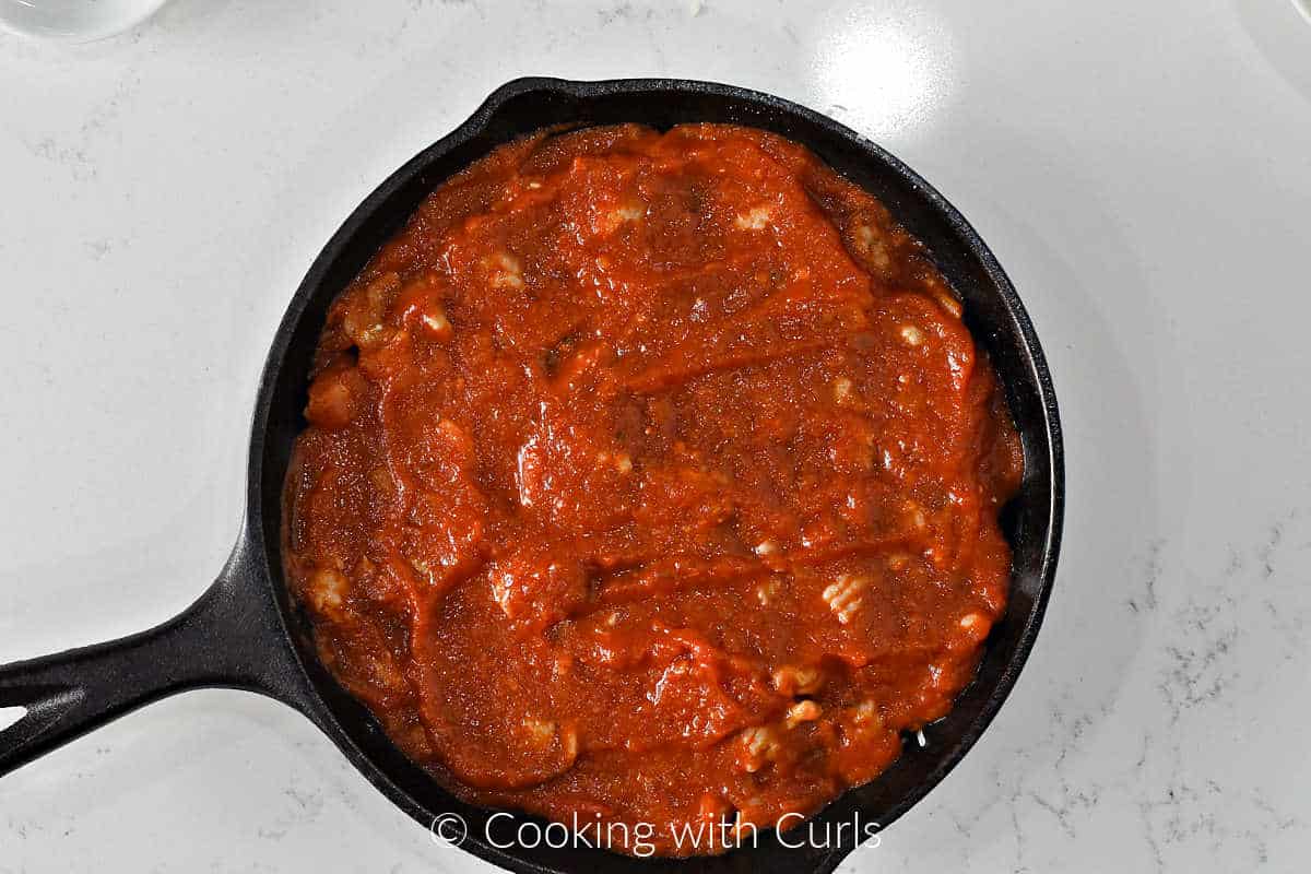 Pizza-sauce-on-sausage-in-a-cast-iron-skillet.