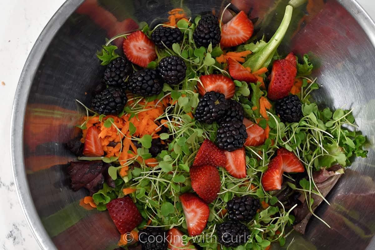Salad ingredients tossed together in a large bowl. 